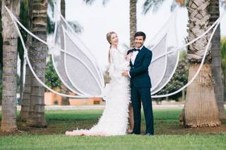 Pareja de recién casados delante de un precioso photocall al aire libre con forma de mariposa