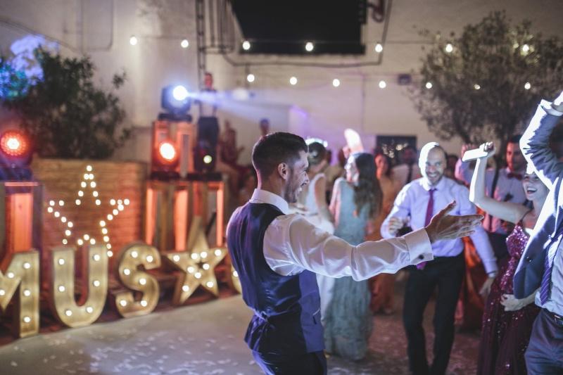 Canciones alegres españolas: chico joven bailando rodeado de chicos y chicas en una pista de baile