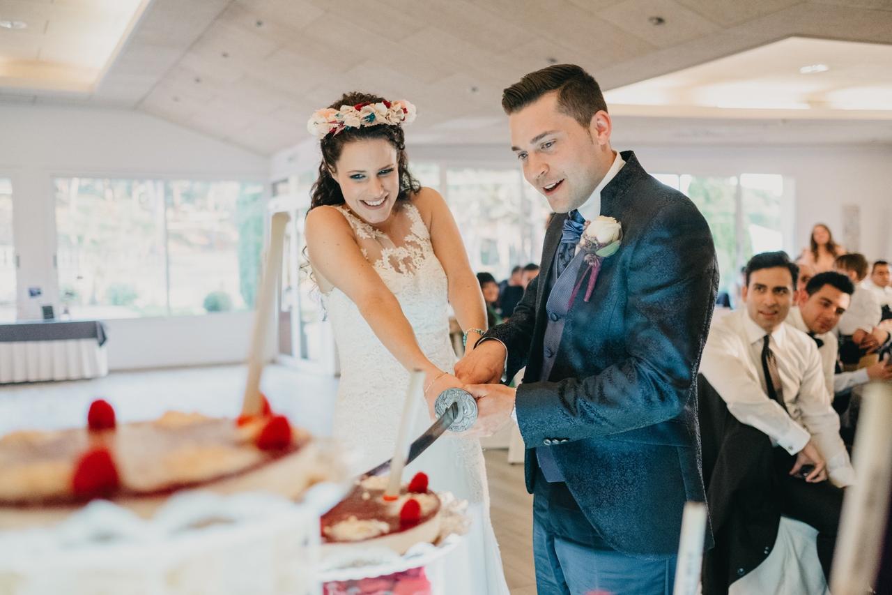 Pareja de recién casados cortando la tarta de boda