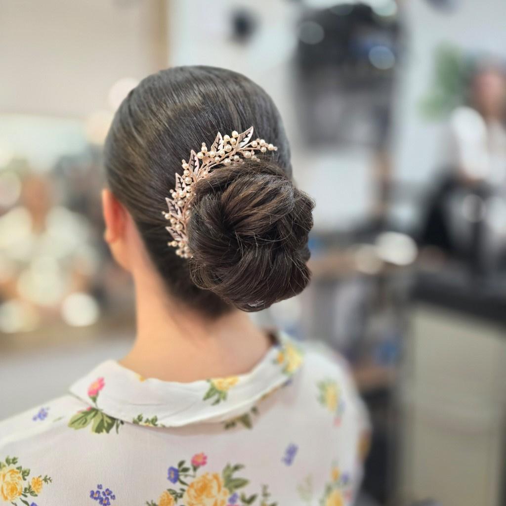 Recogidos invitada boda: moño con adorno joya a un lado en pelo moreno