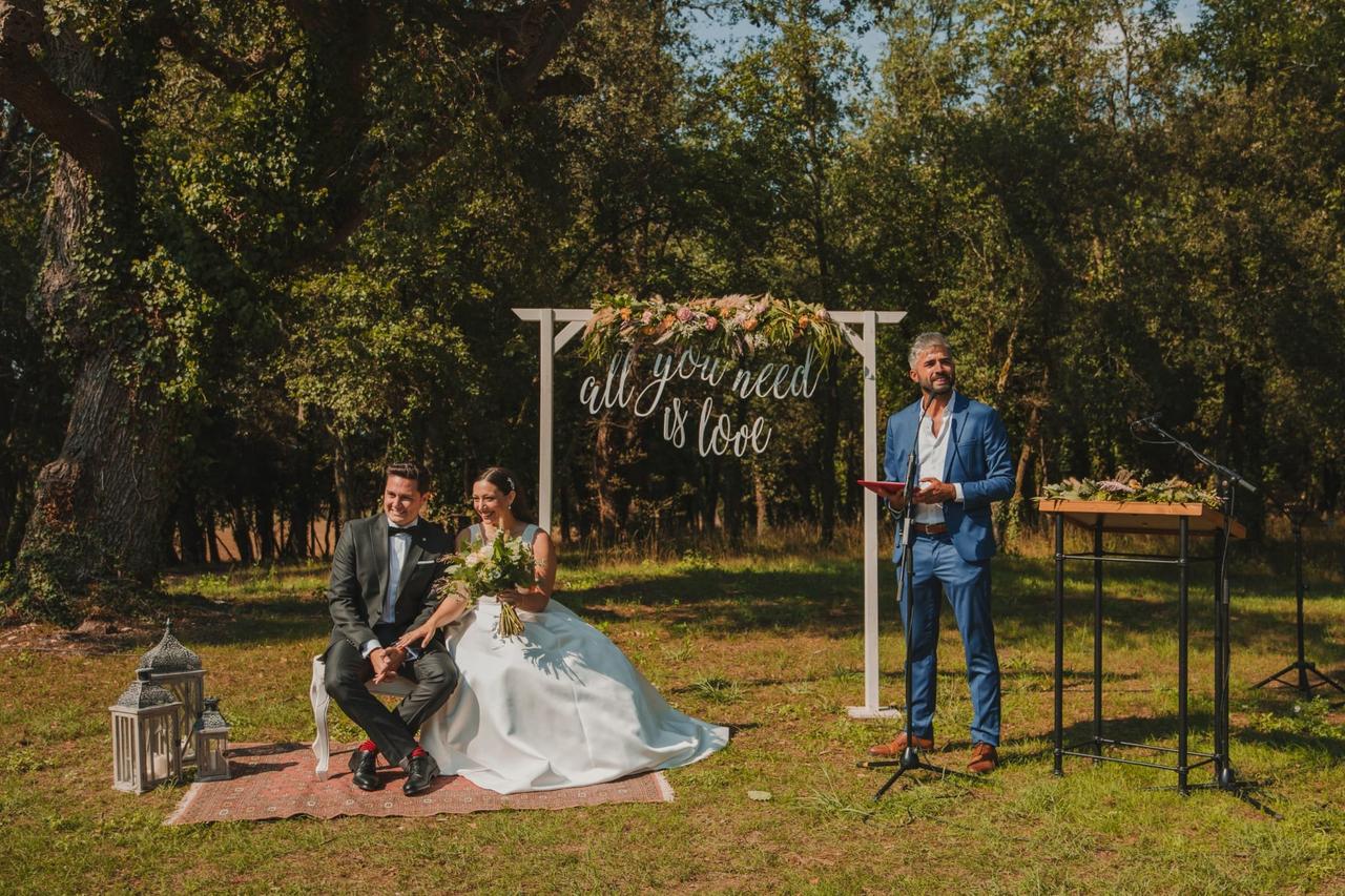 Oficiante de bodas: chico con traje azul oficiando una ceremonia civil al aire libre