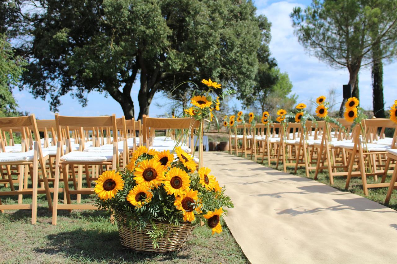 Flores para boda: girasoles en un cesto y decorando los laterales de algunas sillas en una ceremonia civil al aire libre