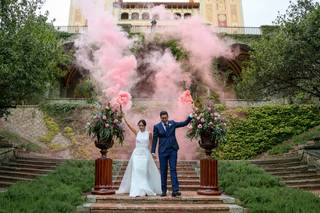 Canciones entrada banquete: pareja de recién casados en una escalera, cogidos de la mano y con bengalas de humo de color