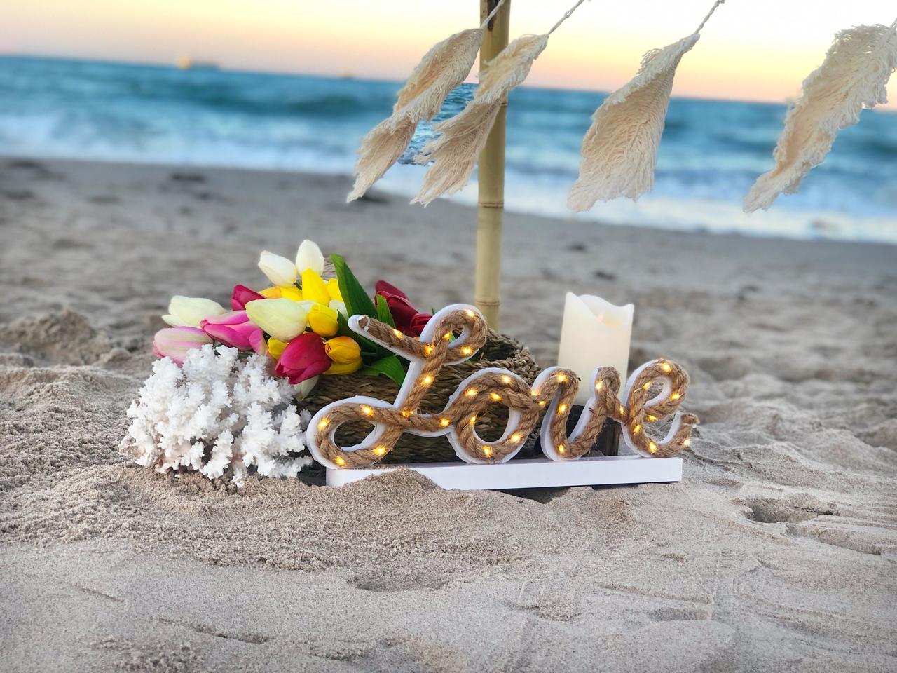 Rincón decorativo con la palabra Love en una boda en la playa