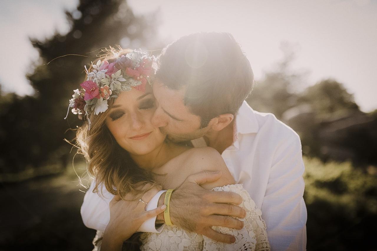Cuando decir te quiero: chico abraza a chica con corona de flores en la cabeza por detrás