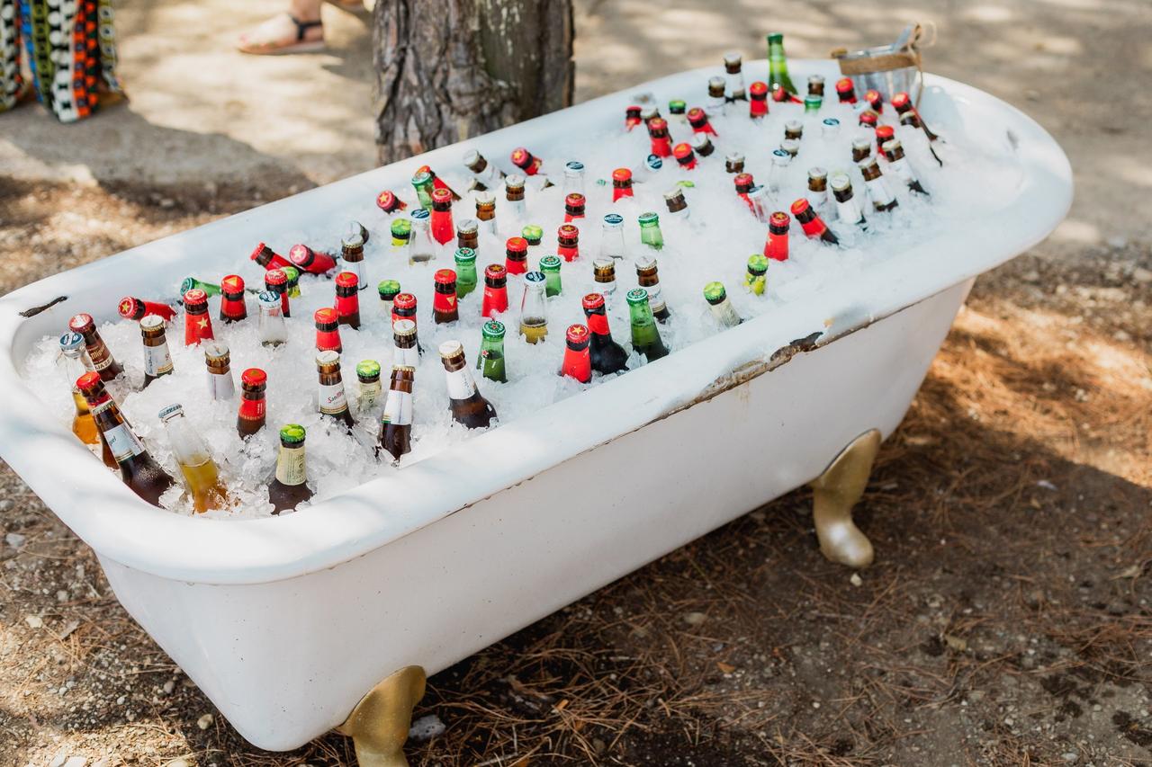 Cerveza para bodas: bañera vintage con patas doradas llena de botellas de cervezas de diferentes marcas y hielo