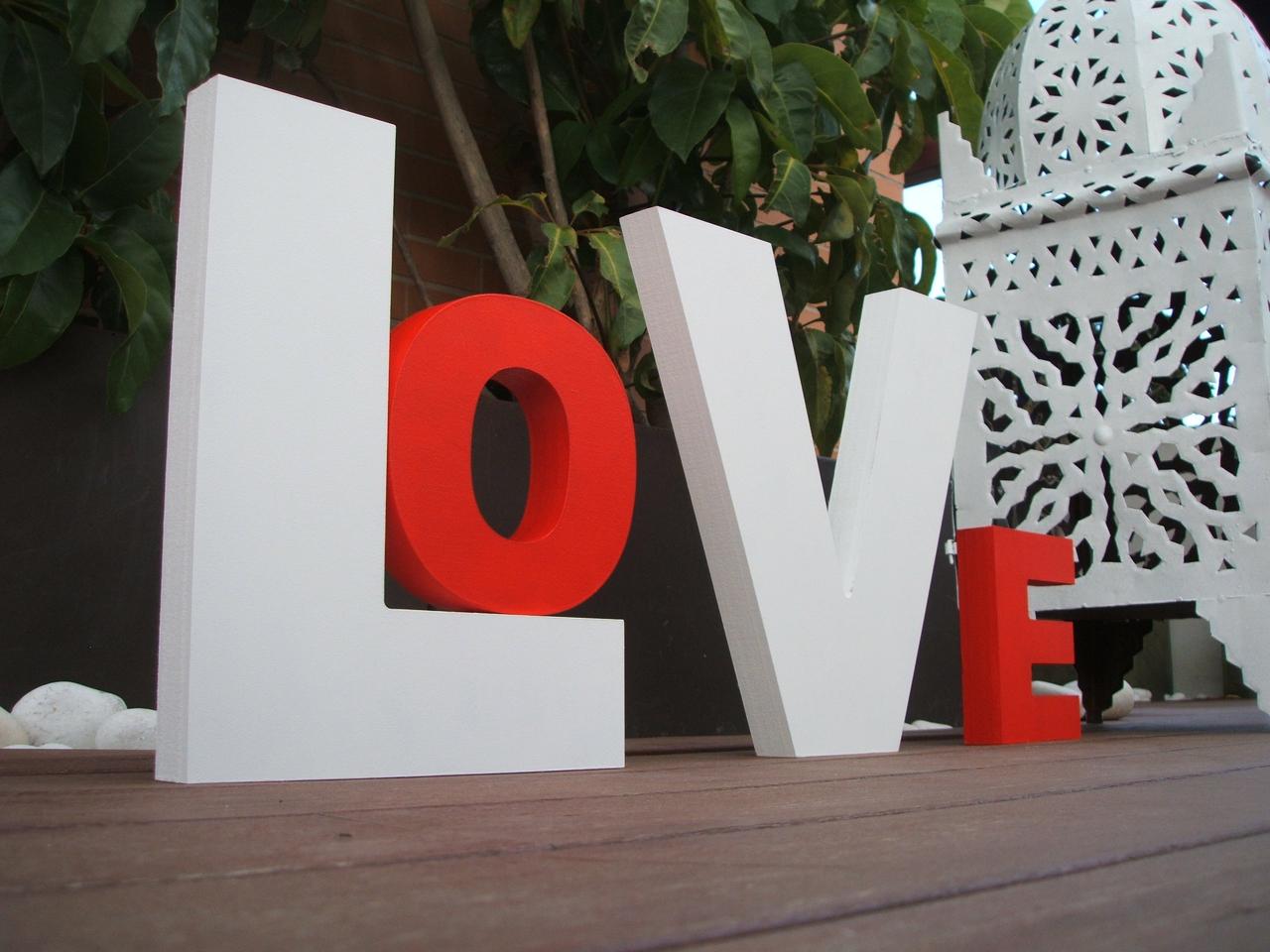 Letras en blanco y rojo en las que puede leerse la palabra Love el día de la boda