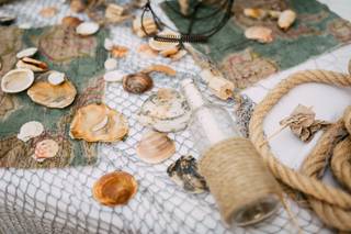 Bodegón decorativo con red de pescador y conchas forma parte de la decoración de una boda en la playa