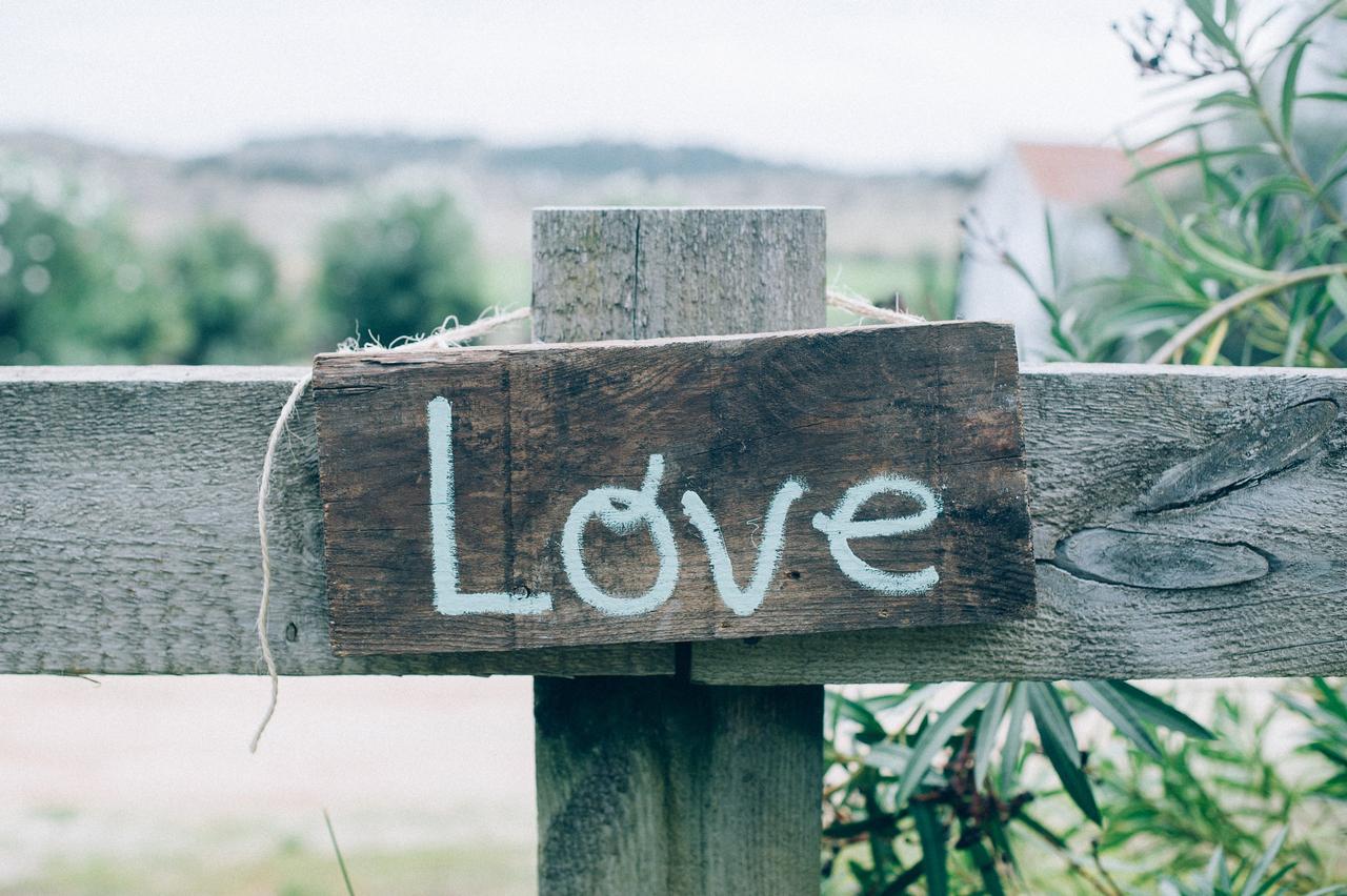 Cartel decorativo de madera el día de la boda en el que puede leerse la palabra Love