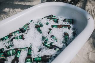 Bañera cervezas boda en un exterior sobre arena y llena de hielo y de cervezas