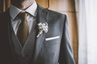 Chico con boutonnière en el ojal de la americana de color gris