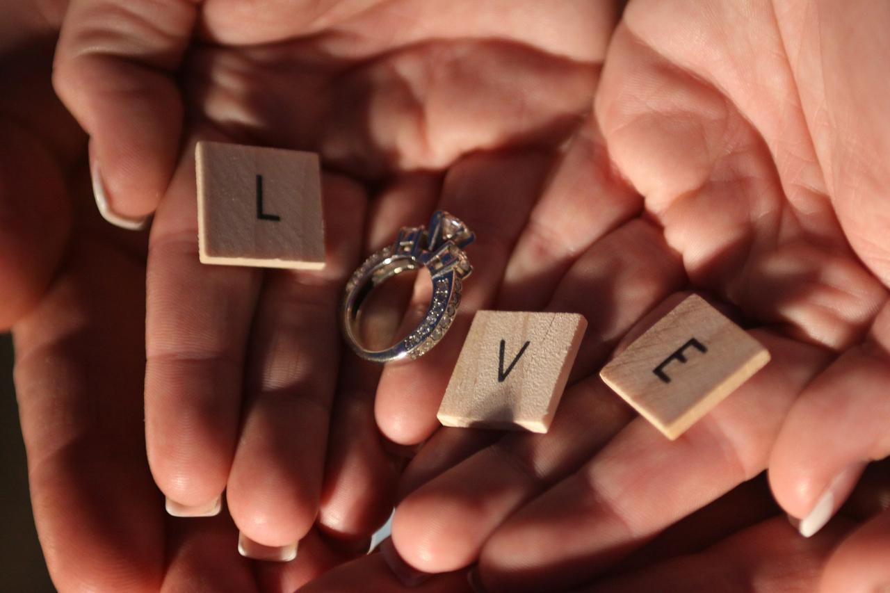 Letras de madera y anillo de pedida que, juntos, forman la palabra Love el día de la boda