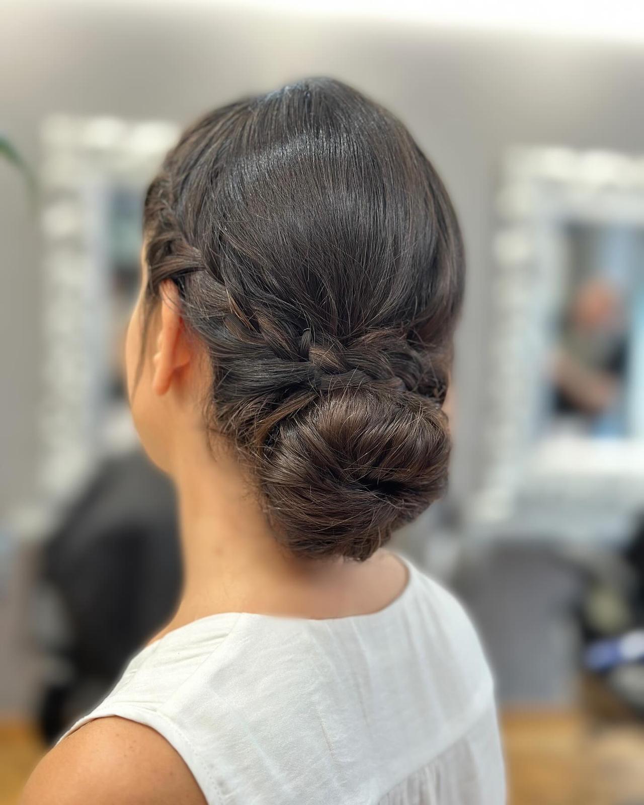 Recogidos invitada boda: moño bajo con trenzas en los laterales en pelo moreno