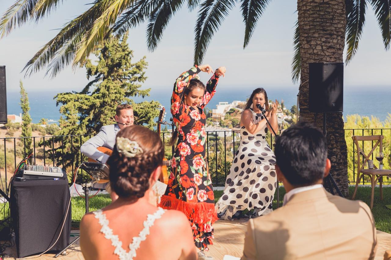 Actuación al aire libre frente a unos novios (de espaldas) de unos músicos y una bailaora de flamenco