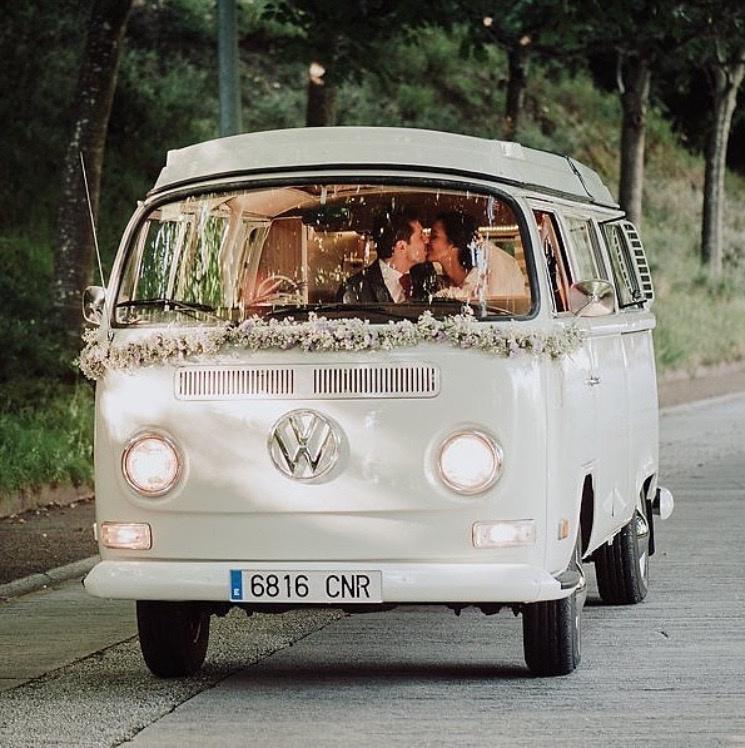 Furgoneta Wolkswagen vintage con una composición floral debajo del parabrisas