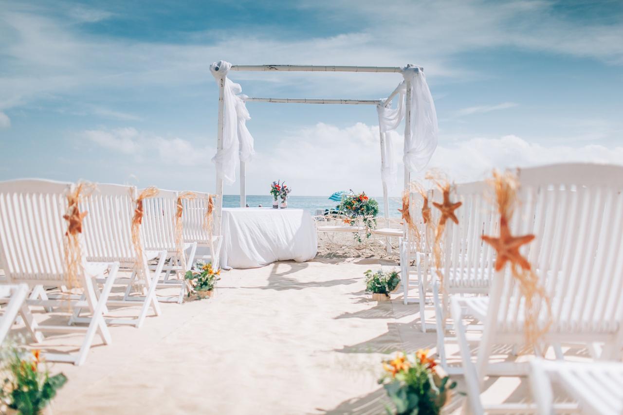 Ceremonia de boda en la playa con estrellas de mar colgando de las sillas