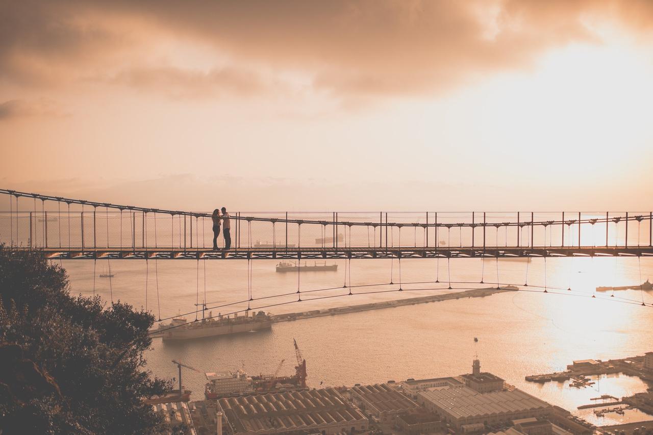 Beneficios de la terapia de pareja: pareja en un puente durante una puesta de sol