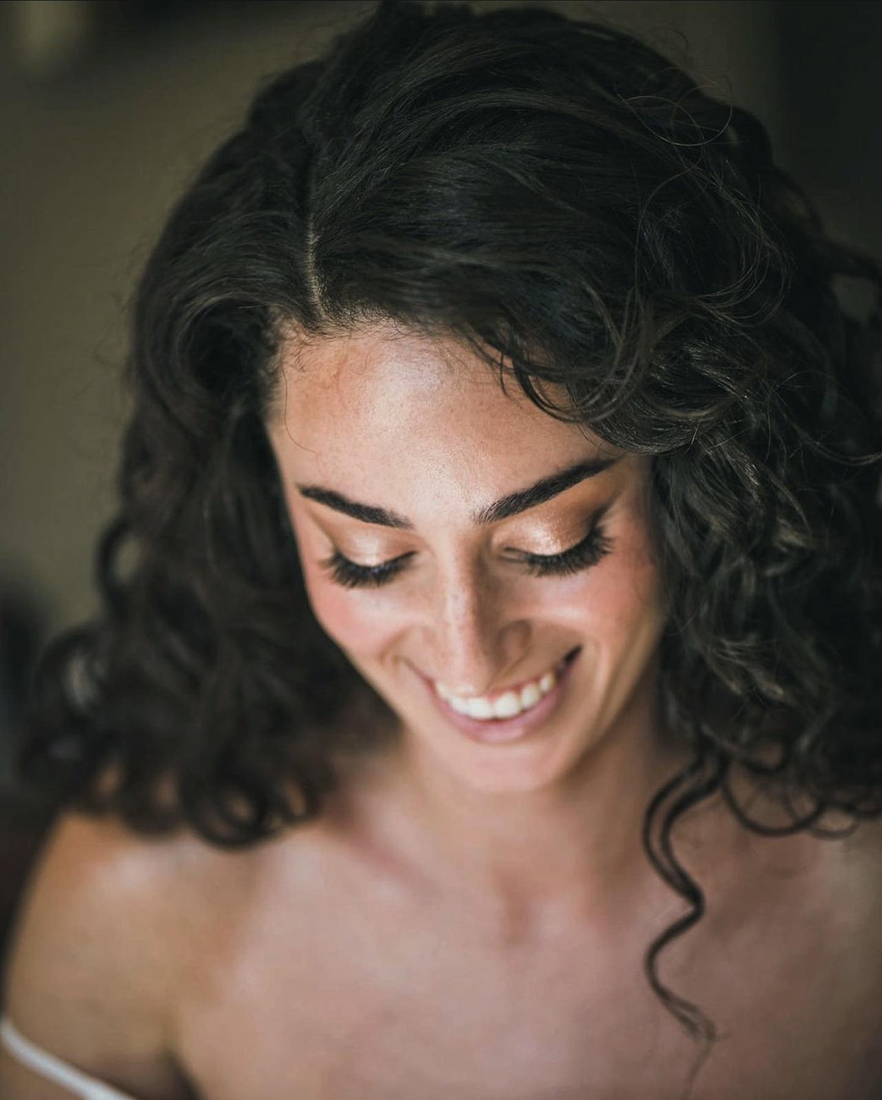 Mujer sonriente con la mirada hacia abajo