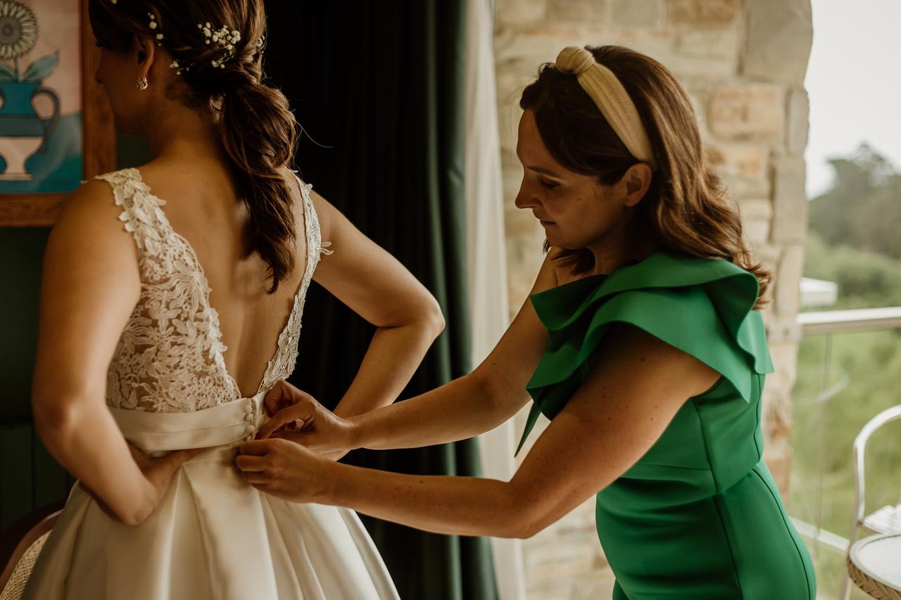 madre ajustandole vestido a su hija
