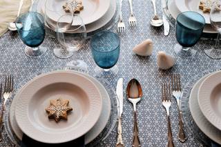 Bodas en Navidad decoración: mesa con copas y mantel azules y con adorno en forma de estrella de Navidad encima de los platos