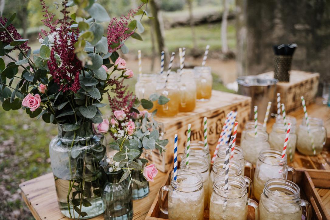 Espacio al aire libre con una mesa con refrescos y cañitas de diferentes colores