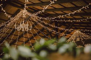 Lámpara de araña y guirnaldas de luces colgando de un techo de madera