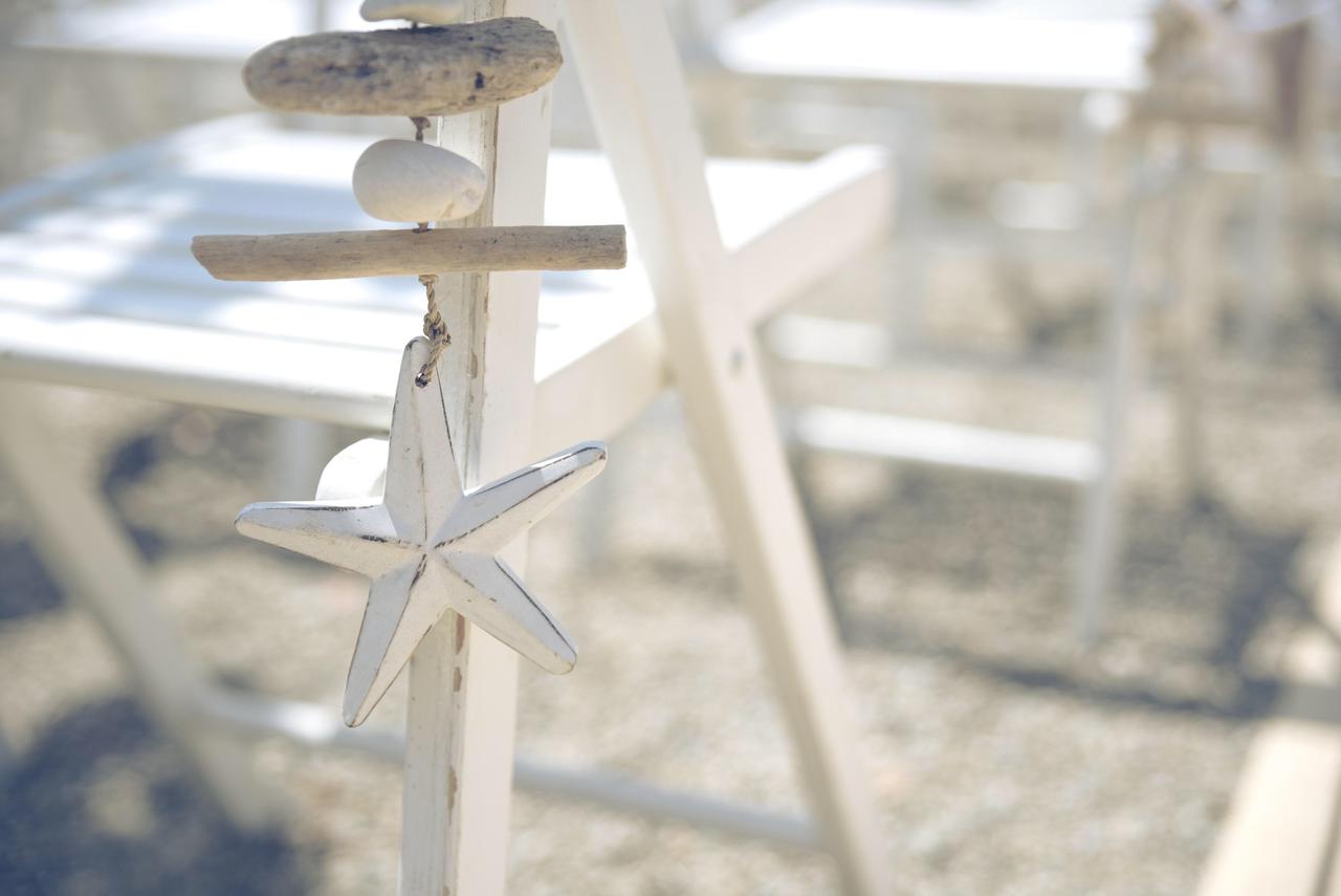 Estrella de mar de madera colgando del respaldo de una silla durante una ceremonia de boda en la playa