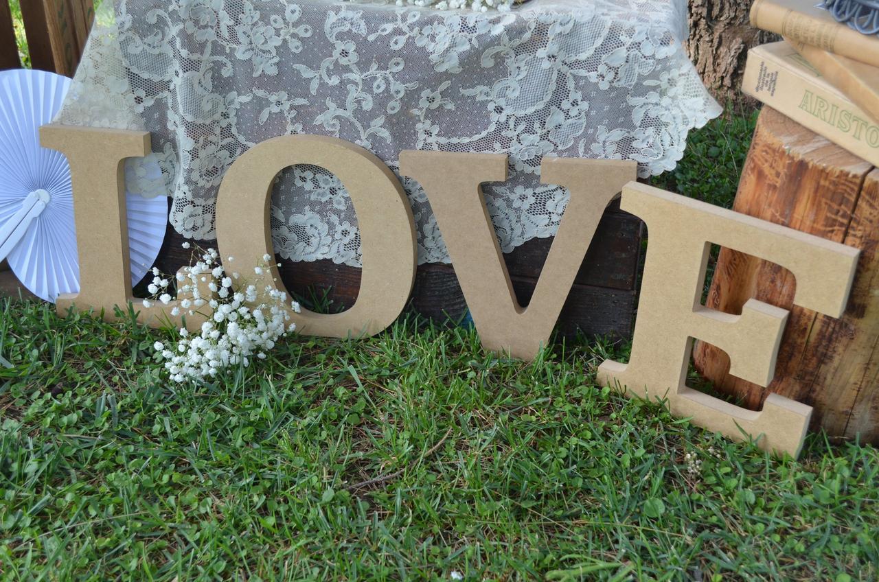 Letras de cartón formando la palabra Love sobre el césped el día de la boda