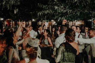 Chicos y chicas muy sonrientes y elegantemente vestidos bailan en una fiesta al aire libre