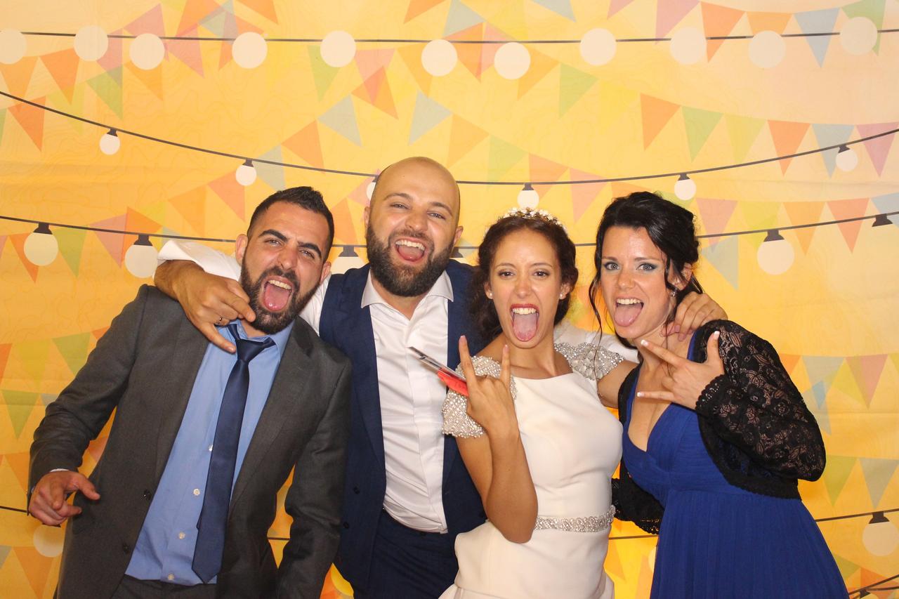 animadores de bodas: pareja de recién casados en un fotomatón de boda con fondo amarillo