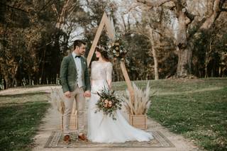 Decoración boda exterior: pareja de recién casados junto al altar de su boda civil al aire libre