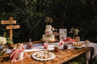 Gran mesa de madera con una tarta y muchas chucherías y dulces