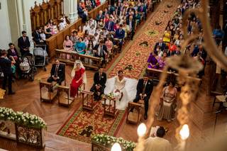 Pareja junto con sus padrinos sentados en el altar de su ceremonia religiosa en una iglesia