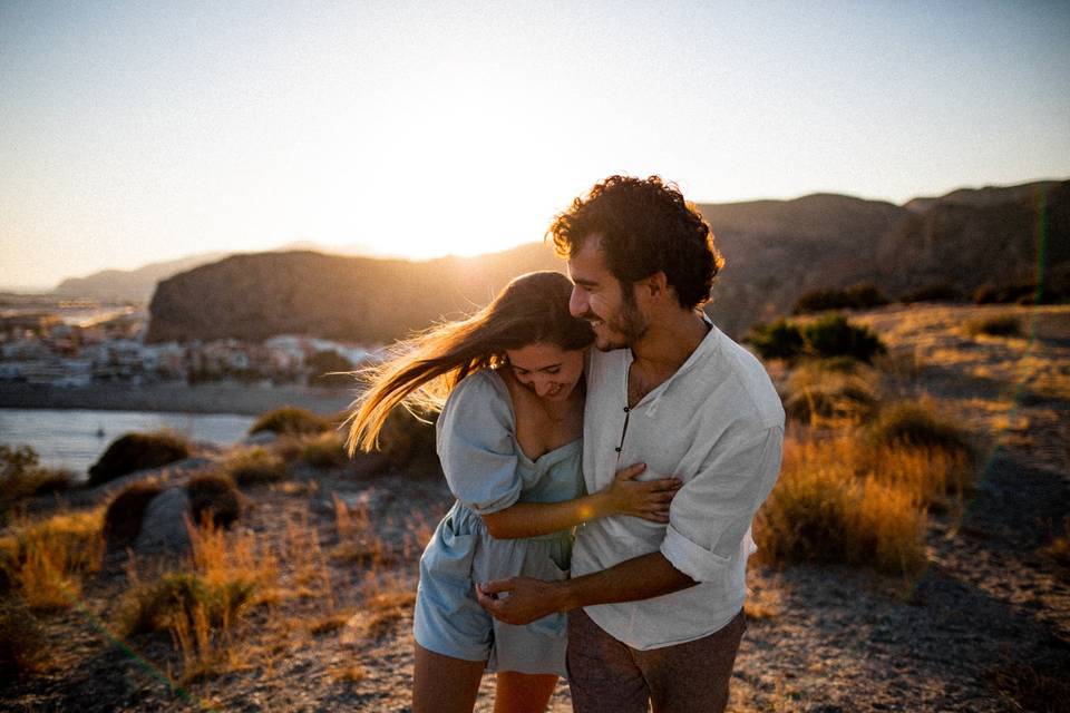 Chico y chica abrazados y muy sonrientes en un espacio exterior durante la puesta de sol, segundas oportunidades