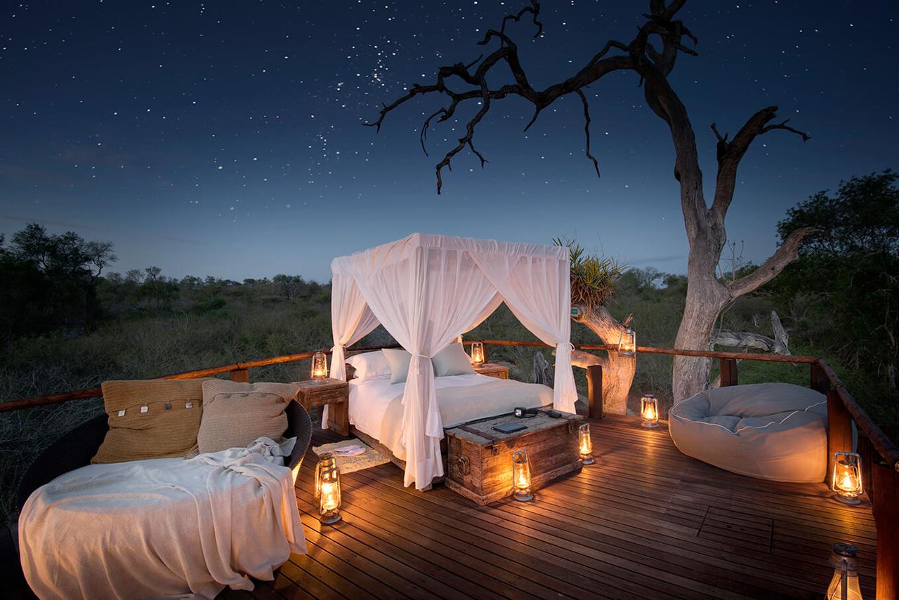 Terraza equipada con una cama y todo tipo de comodidades en medio de un paisaje natural