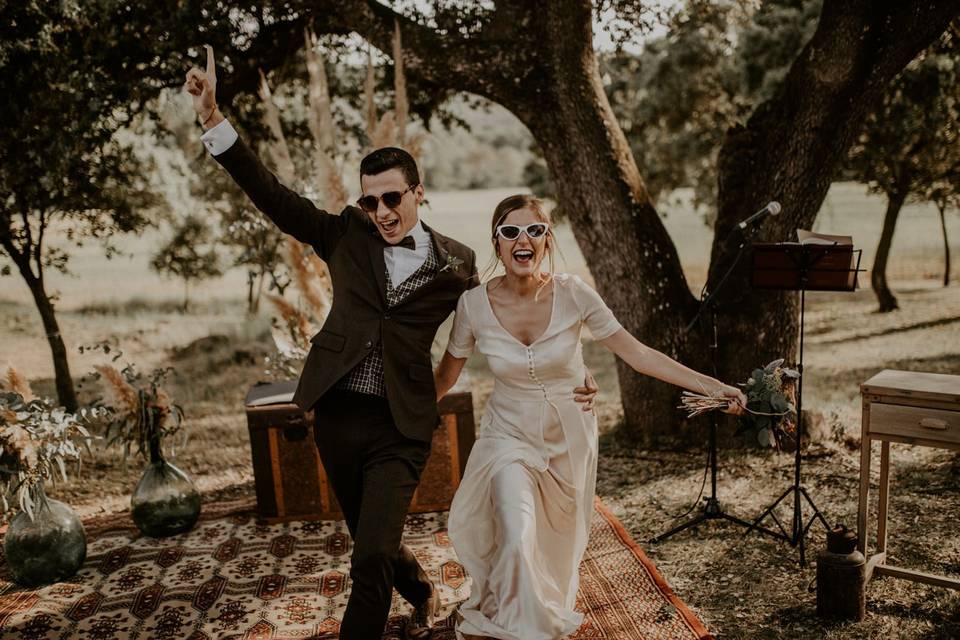 Bodas en verano: pareja de recién casados con gafas de sol en el altar de su boda civil al aire libre