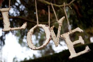 Letras sujetas de la rama de un árbol el día de la boda formando la palabra Love