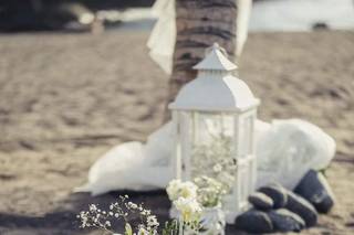 Boda ibicenca decoración con jarroncitos blancos con flores y farolillos del mismo color