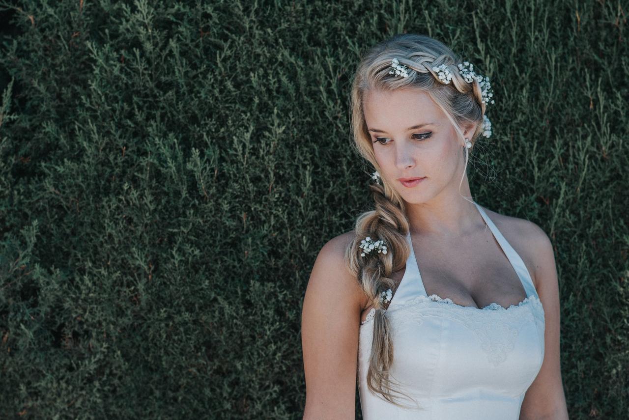 Peinado trenza: novia con trenza muy abierta lateral y detalle decorativo de flores