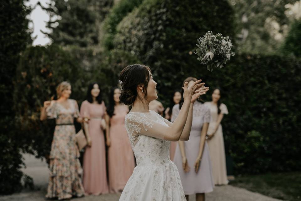 Novia durante el lanzamiento del ramo de novia a las invitadas que esperan detrás de ella