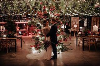 Bodas en Navidad decoración: pareja de recién casados abrazados en un salón interior con ambientación navideña