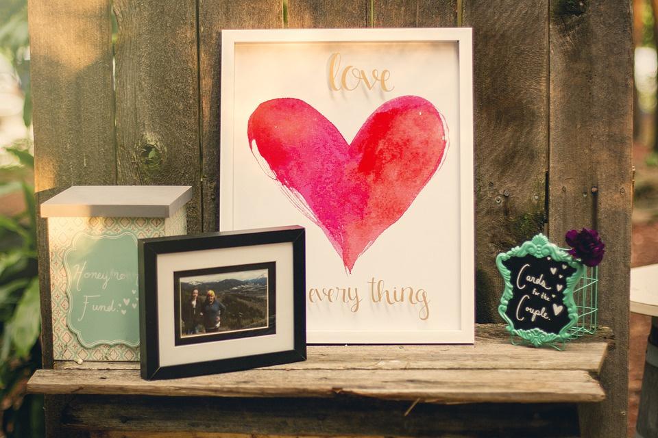 Cuadro decoratico con la palabra Love y un corazón rojo el día de la boda