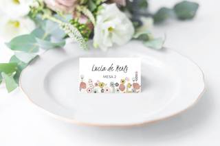 Plato blanco con una tarjeta decorada con flores en la que se puede leer 