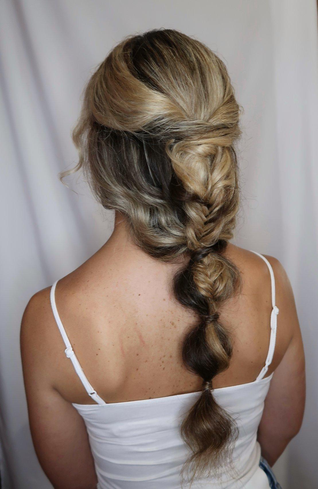 peinados trenzas boda: mujer de espaldas con trenza deshecha en pelo con mechas rubias