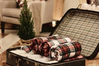 Bodas en Navidad decoración: maletas vintage con mantas junto a un abeto navideño decorativo