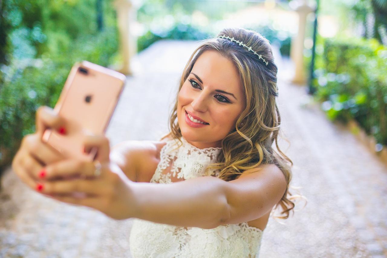 una novia haciéndose un selfie con su móvil el día de su boda
