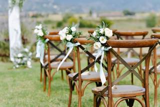 Decoración boda exterior: sillas de madera decoradas con ramilletes de flores