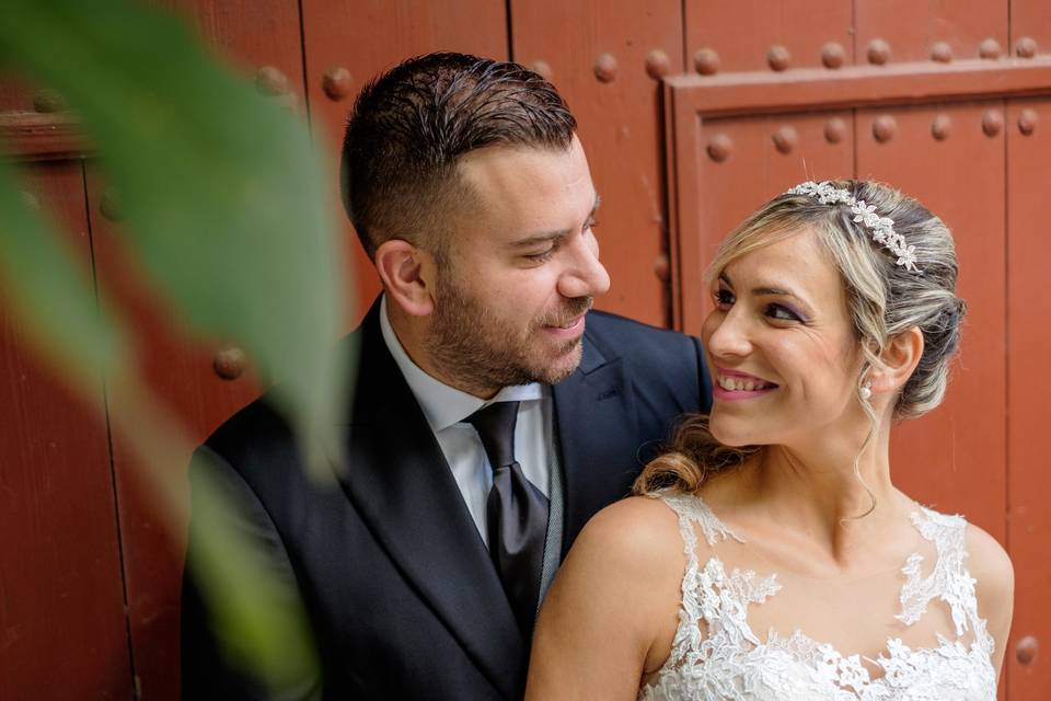 Nudo corbata: pareja de recién casados se mira a los ojos delante de una gran puerta en color marrón