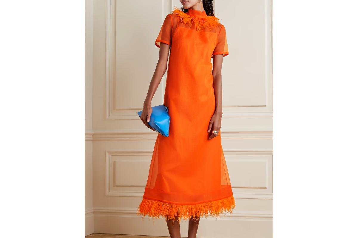 vestido de fiesta naranja con plumas en el cuello alto y en el bajo de la falda