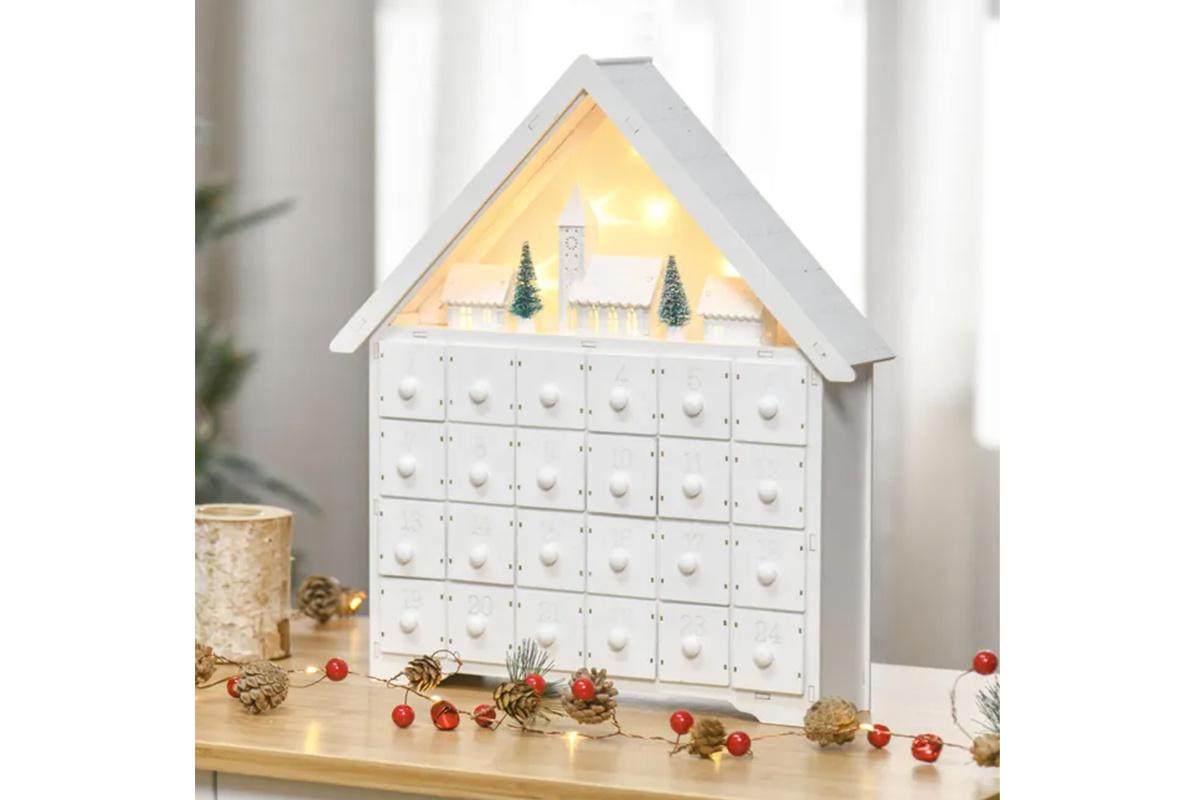 Calendario de Adviento blanco, con forma de casita, y con una bonita imagen navideña con iluminación bajo el tejado
